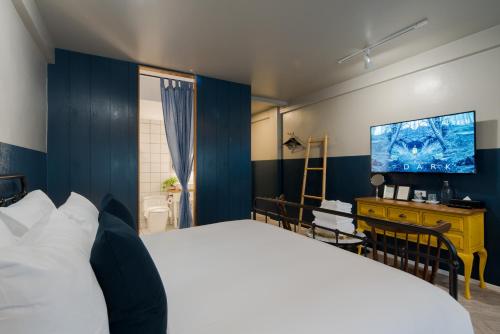 a bedroom with a large bed and a flat screen tv at Blu Monkey Boutique Phuket Town in Phuket Town