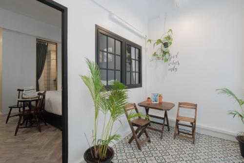 a room with a table and chairs and a bedroom at Blu Monkey Boutique Phuket Town in Phuket Town