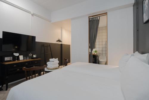 a bedroom with a bed and a desk and a tv at Blu Monkey Boutique Phuket Town in Phuket Town