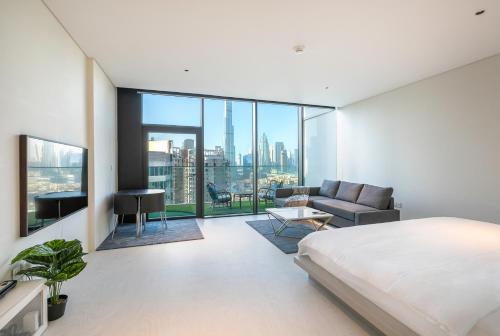 a bedroom with a king sized bed and a couch at Burj Khalifa View, Marquise Square in Dubai