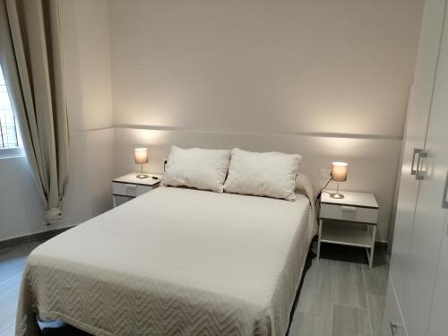 sypialnia z białym łóżkiem i 2 szafkami nocnymi w obiekcie Chimihome w Kordobie
