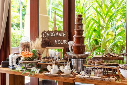 a buffet of food on a wooden table at Mövenpick Asara Resort & Spa Hua Hin in Hua Hin