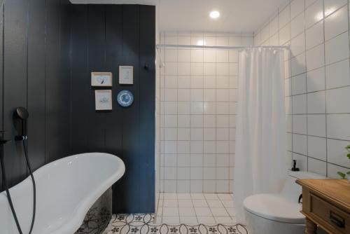 a bathroom with a tub and a toilet and a shower at Blu Monkey Boutique Phuket Town in Phuket Town
