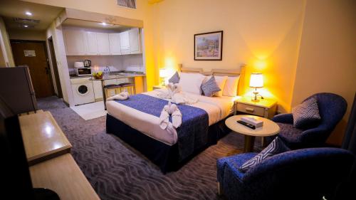 a hotel room with a bed and a kitchen at Green House Hotel Suites & Apartment in Dubai