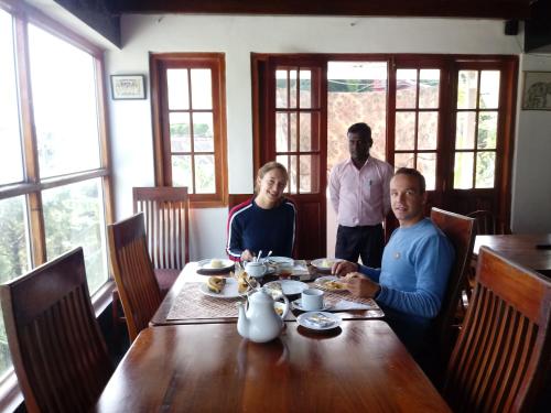 un grupo de tres personas sentadas en una mesa en Eco Creations Nuwaraeliya, en Nuwara Eliya