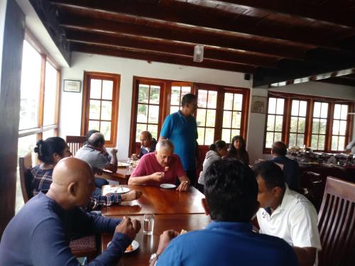 un grupo de personas sentadas alrededor de una mesa en una habitación en Eco Creations Nuwaraeliya, en Nuwara Eliya