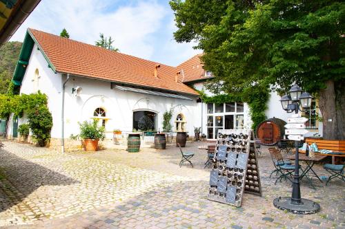 ein weißes Gebäude mit einem Tisch und Stühlen davor in der Unterkunft Hotel Annaberg in Bad Dürkheim