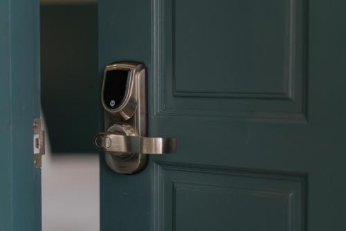 a door with a metal handle on a green door at Blu Monkey Boutique Phuket Town in Phuket Town