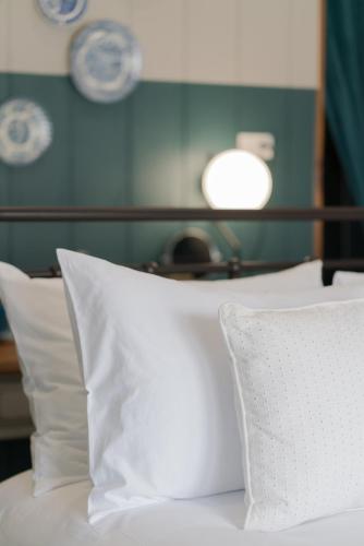 a white bed with white pillows and a lamp at Blu Monkey Boutique Phuket Town in Phuket Town