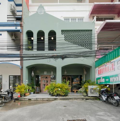 a green building with a balcony on a street at Blu Monkey Boutique Phuket Town in Phuket Town
