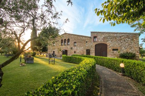 an old stone building with a hedge in front of it at Hotel Mas Rabiol -Costa Brava-Emporda-Only Adults in Peratallada