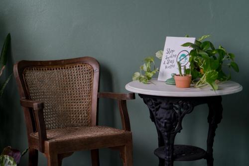 a table with a chair and a table with plants on it at Blu Monkey Boutique Phuket Town in Phuket Town