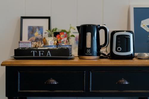 a table with a coffee pot and a coffee maker on it at Blu Monkey Boutique Phuket Town in Phuket Town