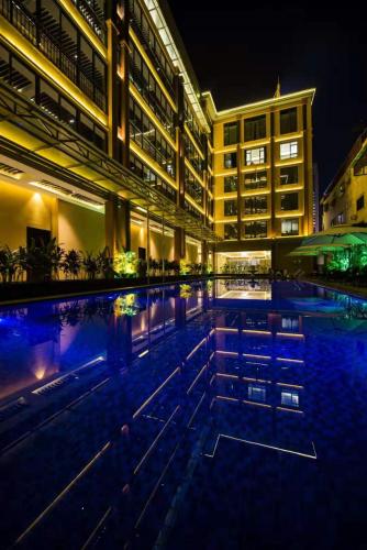 a swimming pool in front of a building at night at Le Chen Miiya Hotel in Sihanoukville