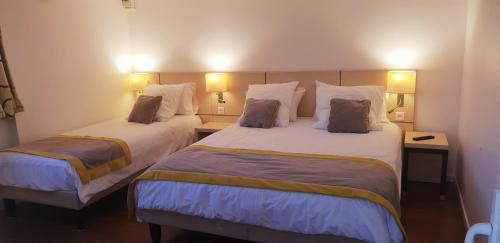 Una habitación de hotel con dos camas y dos lámparas. en Le Mas de la Frigoulette, en Sanary-sur-Mer