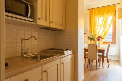 a small kitchen with a sink and a table at Magic Signoria Apartment in Florence