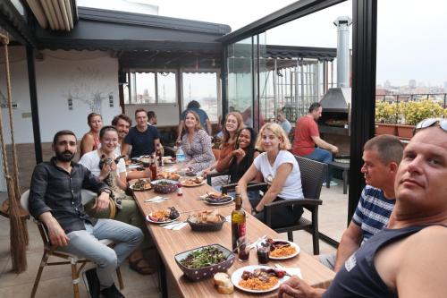 a group of people sitting around a table eating food at Second Home Suites in Istanbul