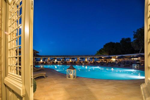 a view of a swimming pool at night at Saint Andrea Seaside Resort - Adults Only in Naousa