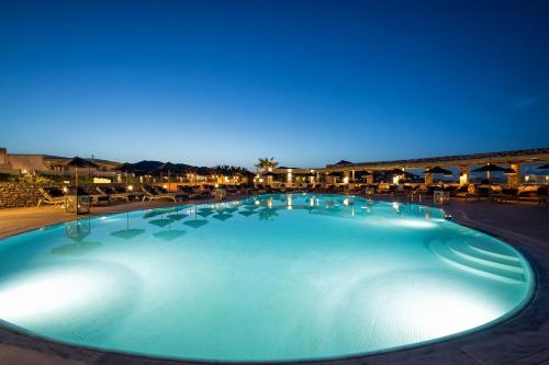 a large swimming pool at a resort at night at Saint Andrea Seaside Resort - Adults Only in Naousa