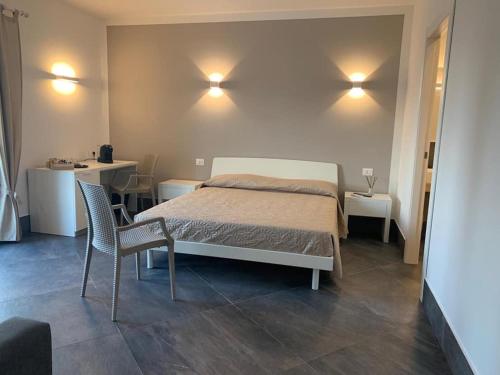 カルタニッセッタにあるB&B Adenziaのベッドルーム1室(ベッド1台、椅子2脚、テーブル付)