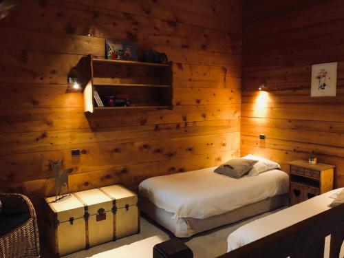 a bedroom with two beds and wooden walls at Le Coin Savoyard in Combloux