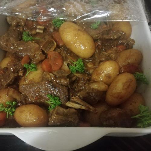 a dish of food with meat and potatoes in a container at faces guesthouse in Bethlehem