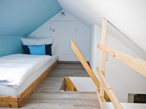 a small bedroom with a bed and a staircase at Lehdsche Heubuchten in Lehde