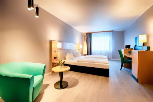 une chambre d'hôtel avec un lit et une chaise dans l'établissement ACHAT Hotel Egelsbach Frankfurt, à Egelsbach