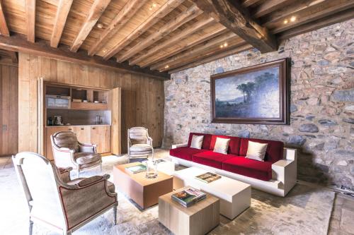 a living room with a red couch and chairs at Domaine des Etangs, Auberge Collection in Massignac