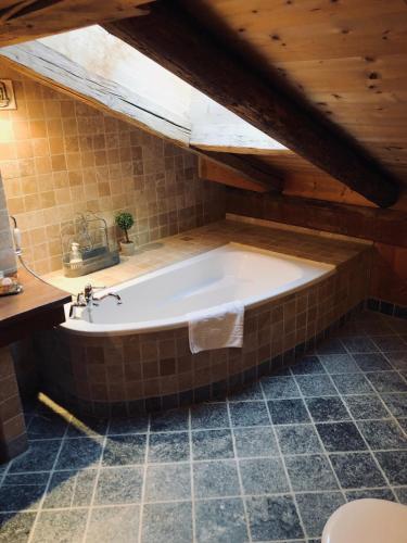 a bath tub in a bathroom with a wooden ceiling at Le Coin Savoyard in Combloux