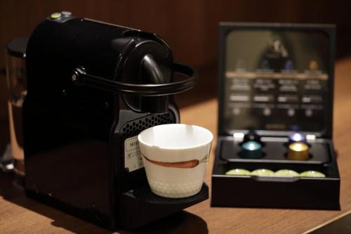 a coffee cup sitting inside of a coffee maker at Yumeguri no Yado Yoshiharu in Izunokuni