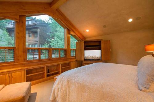ein Schlafzimmer mit einem Bett und einem großen Fenster in der Unterkunft Northwoods Steps to Chairlift in Vail