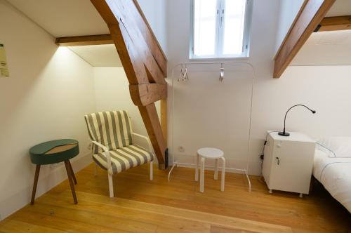 a bedroom with a bed and a chair and a table at Change The World Hostels - Coimbra - Almedina in Coimbra