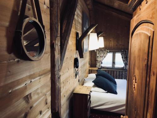 a bedroom with a bed in a wooden cabin at Le Coin Savoyard in Combloux