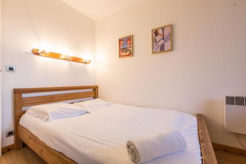 een kleine slaapkamer met een bed met witte lakens bij Apartment Chamois Blanc 6 in Chamonix-Mont-Blanc