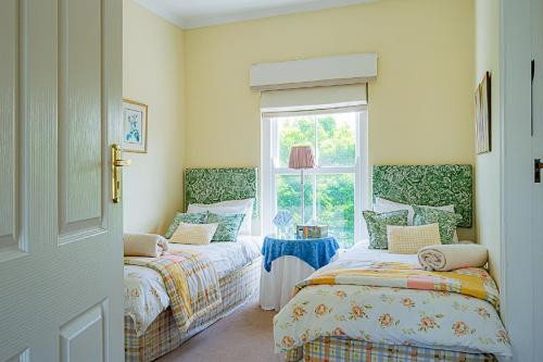 a bedroom with two beds and a window at 56B Gowrie Village in Nottingham Road