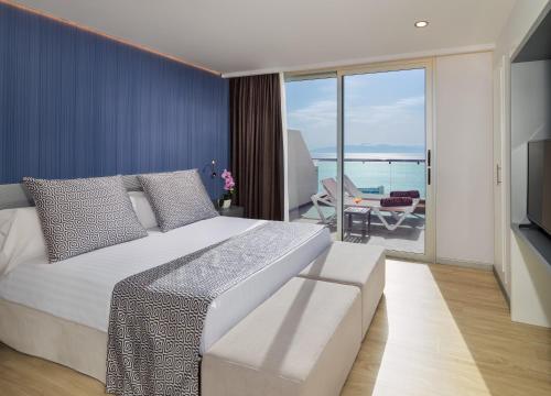 a bedroom with a large bed and a view of the ocean at Royal Sun Resort in Acantilado de los Gigantes