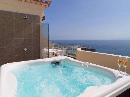 a swimming pool with a large white tub next to a beach at Royal Sun Resort in Acantilado de los Gigantes