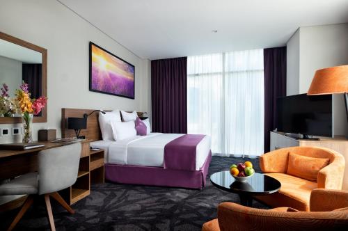 a hotel room with a bed and a desk at Park Regis Business Bay in Dubai