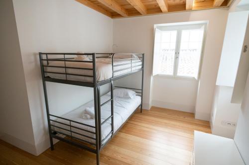 a room with two bunk beds and a window at Change The World Hostels - Coimbra - Almedina in Coimbra