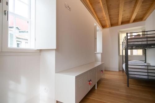 a bedroom with a bunk bed and a bunk room with a ladder at Change The World Hostels - Coimbra - Almedina in Coimbra