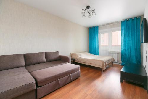 ein Wohnzimmer mit einem Sofa und einem Bett in der Unterkunft Apartments Freedom in Nowosibirsk