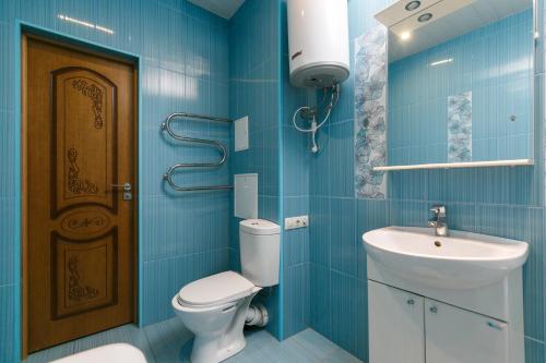 a blue bathroom with a toilet and a sink at Apartments Freedom in Novosibirsk
