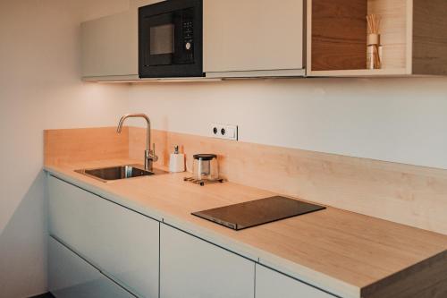 a kitchen counter with a sink and a microwave at Beautiful new studio, 400m from the square in Pilsen