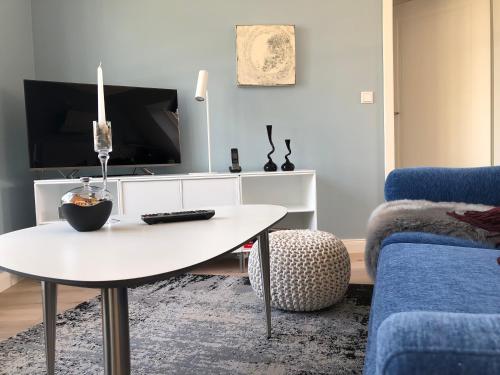uma sala de estar com uma mesa e uma televisão em Oldsens - Wohnen zwischen Wind und Weite em Oevenum