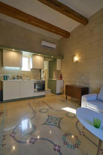 a large living room with a couch and a kitchen at Magic in the Heart of Old Gozo (Penthouse) in Victoria