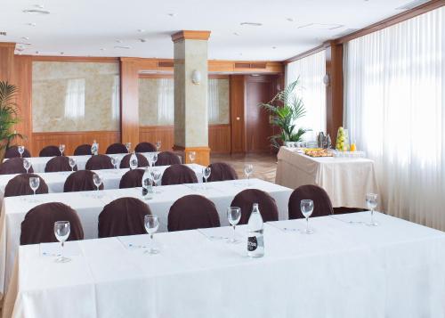 a conference room with white tables and chairs with wine glasses at VP Jardín de Tres Cantos in Tres Cantos