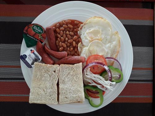 a plate of breakfast food with beans beans and eggs at His Majesty's Hotel and Apartments in Accra