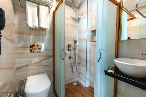 a bathroom with a toilet, sink and shower at City Hall Hotel in Istanbul