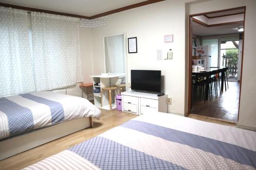 a bedroom with two beds and a flat screen tv at Jeong House in Seoul
